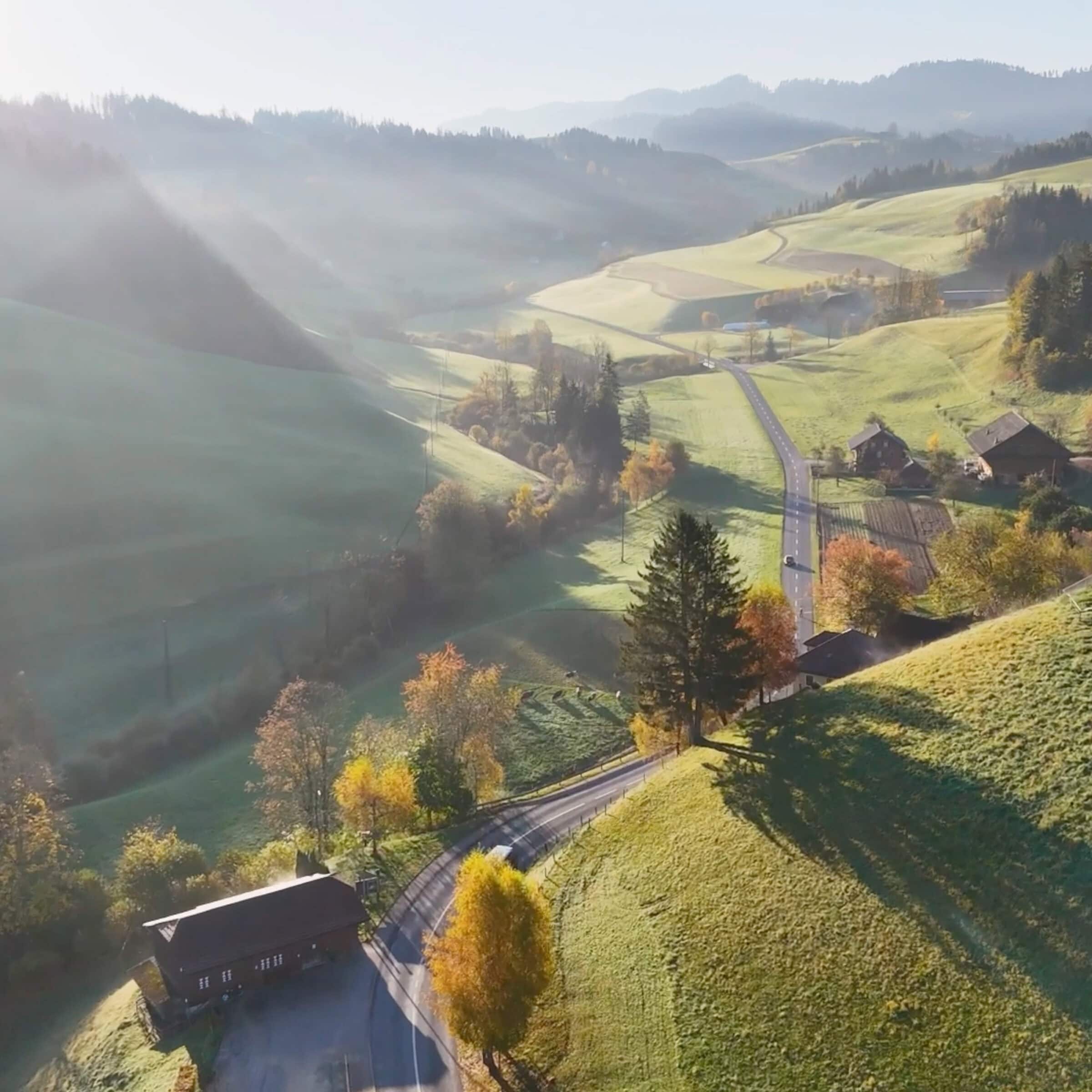 luftaufnahme einer hügeligen landschaft im luzerner hinterland bei morgensonne
