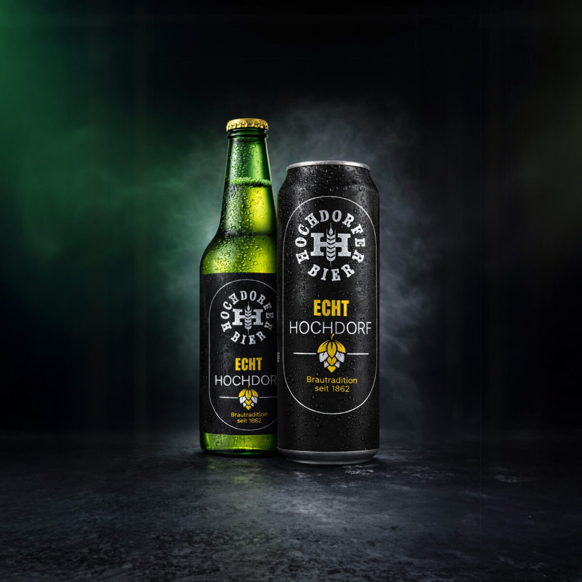 flasche und dose hochdorfer bier «echt hochdorf» vor dunklem hintergrund
