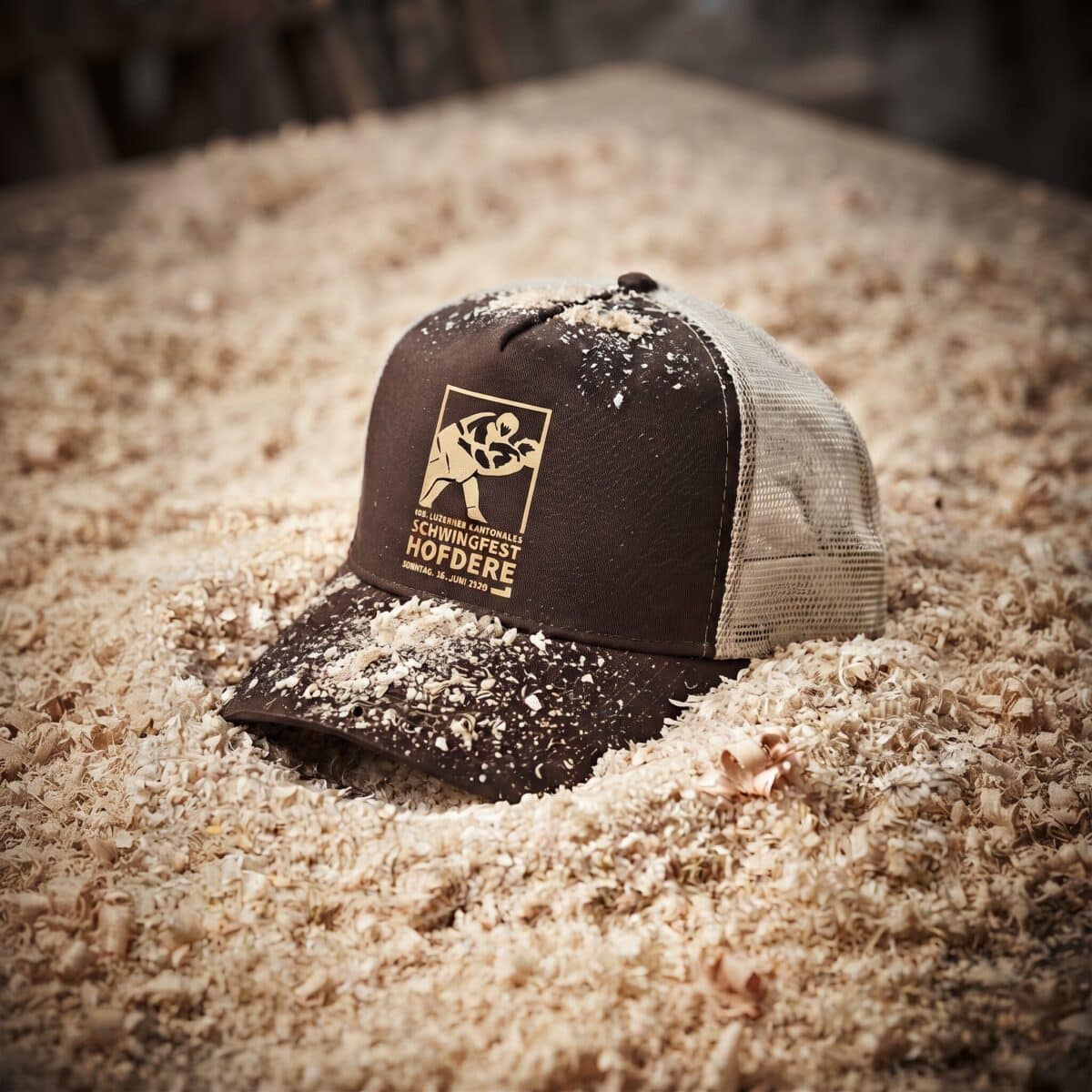braune cap mit dem logo des schwingfests hofdere im sägemehl