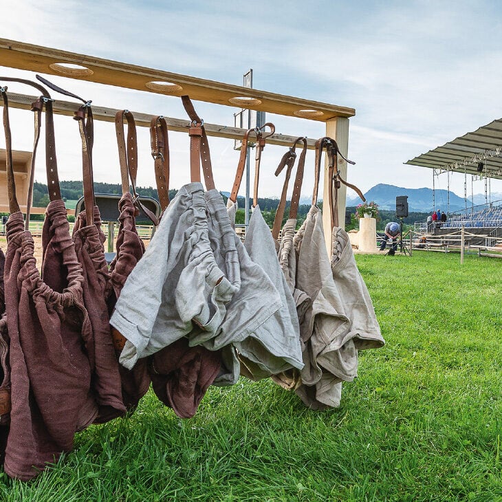 schwingerhosen hängen an einer holzstange auf dem festgelände