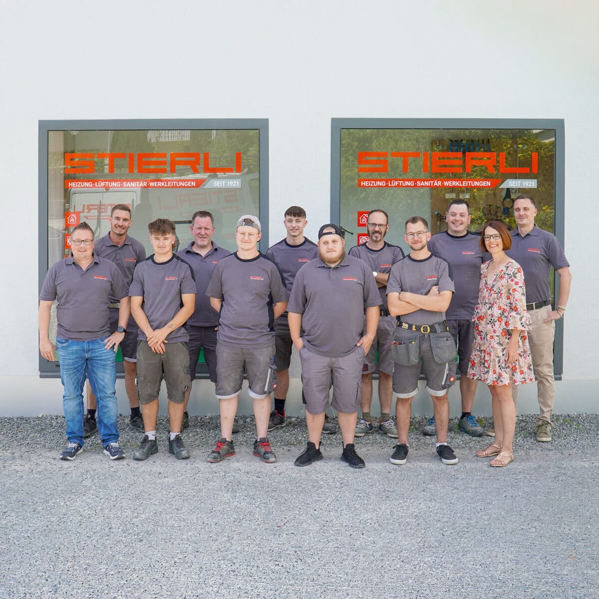 team der stierli gmbh vor dem geschäft mit beschrifteten schaufenstern
